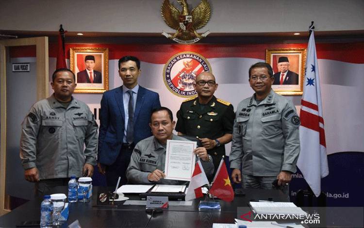 Kepala Bakamla Laksdya TNI Aan Kurnia (tengah) menunjukkan dokumen nota kesepahaman kerja sama antara Bakamla dan Vietnam Coast Guard yang telah diteken di Jakarta, Selasa (28/12/2021). ANTARA/HO-Humas Bakamla RI