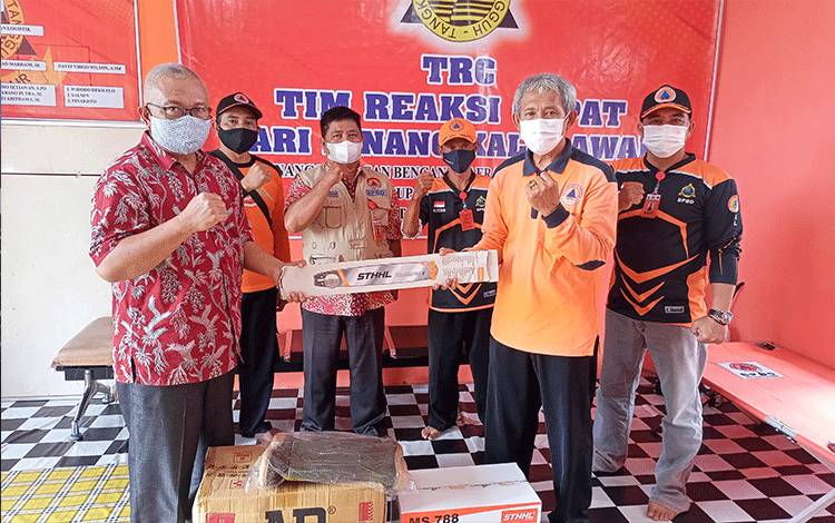 Kalaksa BPBD Damkar Kabupaten Barito Timur, Riza Rahmadi menyerahkan secara simbolis senso dan sepatu bot kepada anggota TRC.