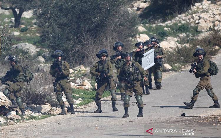 Tentara Israel bersiaga memegang senjata mereka dalam bentrokan dengan para pengunjuk rasa Palestina menyusul aksi protes menentang ekspansi permukiman Yahudi di Desa Kufr Qadoom di dekat Kota Nablus, Tepi Barat, Jumat (18/12/2020). ANTARA FOTO/Xinhua/Nidal Eshtayeh/pras.