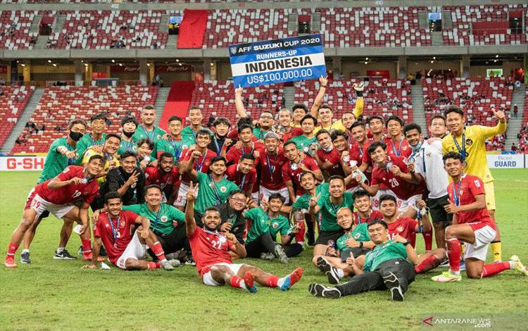 Sejumlah pesepak bola dan tim pelatih Timnas Indonesia berfoto bersama usai pengalungan medali Piala AFF 2020 di National Stadium, Singapura, Sabtu (1/1/2022). ANTARA FOTO/Flona Hakim/app/hp. (ANTARA FOTO/FLONA TOBING)