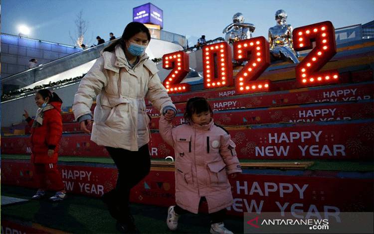 Seorang perempuan berjalan dengan seorang anak melewati instalasi 2022 pada Malam Tahun Baru di tengah pandemi COVID-19 di sebuah pusat perbelanjaan di Beijing, China, Jumat (31/12/2021). ANTARA FOTO/REUTERS/Florence Lo/aww.