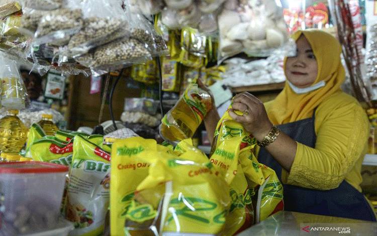 Seorang pedagang menunjukkan minyak goreng kemasan dagangannya di Pasar Malaka, Rorotan, Jakarta, Senin (3/1/2022). ANTARA FOTO/M Risyal Hidayat/aww