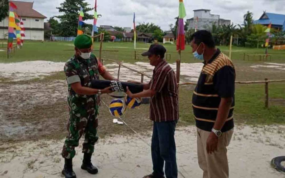Pasiter Kodim 1014 Pangkalan Bun, Kapten Inf Mulyono saat menyerahkan bantuan bola voli dan net kepada warga, Selasa, 4 Januari 2021.