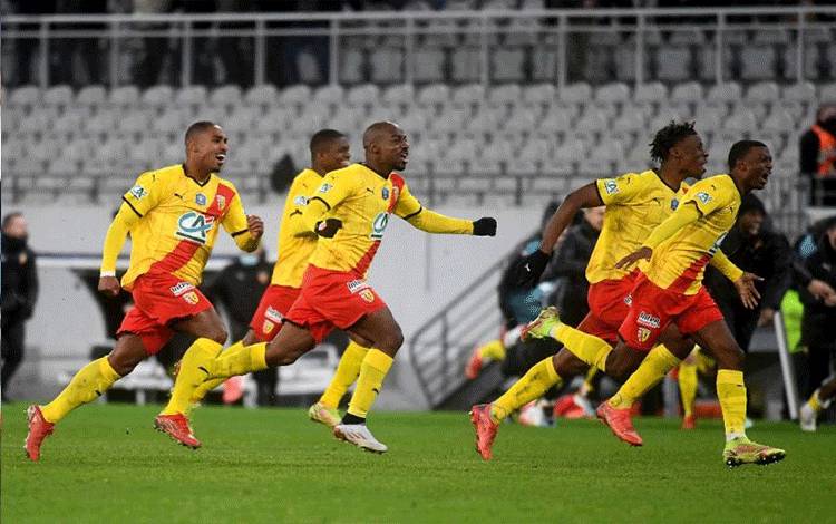 Para pemain Lens merayakan kelolosan mereka ke 16 besar Piala Prancis setelah menang adu penalti melawan Lille dalam 32 besar kompetisi ini setelah skor 2-2 bertahan sampai 120 menit di  Bollaert-Delelis Stadium di Lens, Prancis, 4 Januari 2022. (AFP/FRANCOIS LO PRESTI)