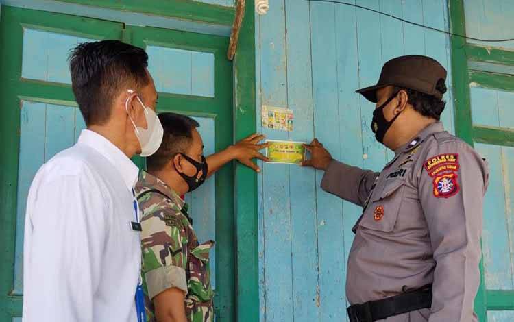 Tim gugus Covid-19 Kotawaringin Lama menempelkan stiker di depan rumah warga yang sudah vaksin