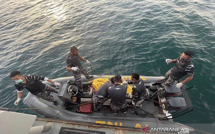 Prajurit TNI AL di KRI Parang-647 mengangkut jasad yang diduga pekerja migran Indonesia yang mengapung di perairan perbatasan Indonesia dan Malaysia, Jumat (7/1/2022). ANTARA/Dinas Penerangan TNI AL