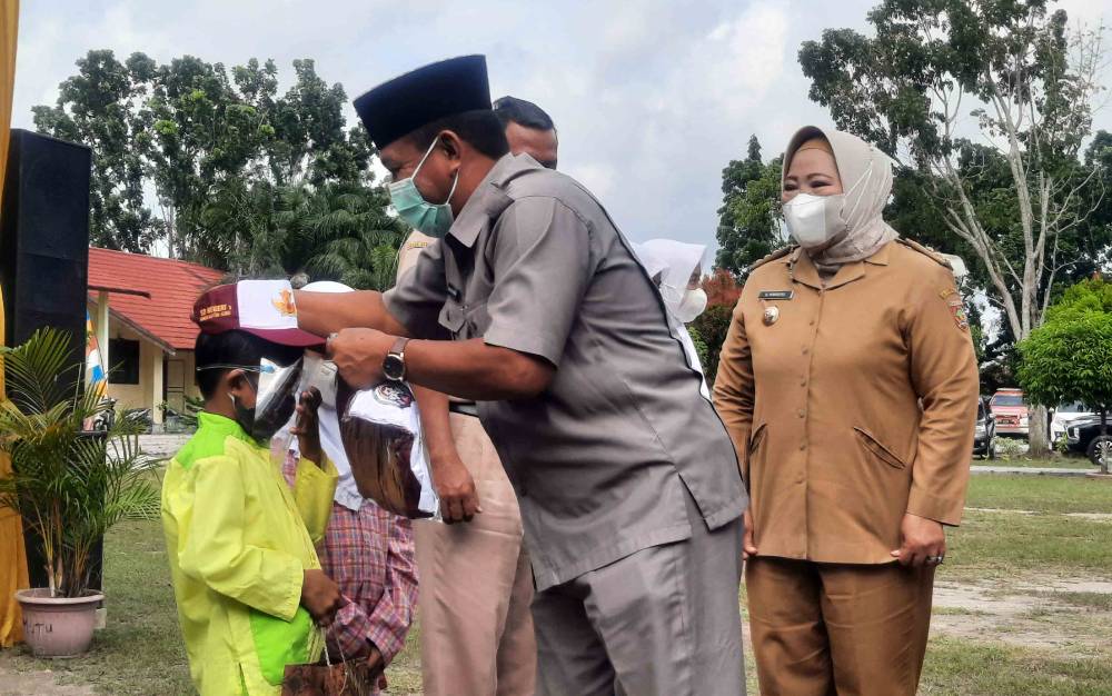 Wakil Ketua II DPRD Kobar Bambang Suherman bersama Bupati Kobar Nurhidayah saat penyerahan seragam sekolah gratis.