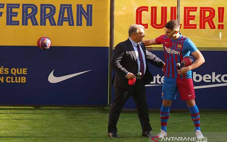 Presiden Barcelona Joan Laporta (kiri) menyambut kedatangan Ferran Torres sebagai pemain anyar Barcelona FC di Stadion Camp Nou, Barcelona, Spanyol (3/1/2022)