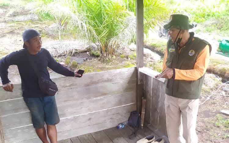 Komandan BKSDA Pos Jaga Sampit, Muriansyah berbincang dengan pemilik pondok yang diganggu keberadaan beruang.