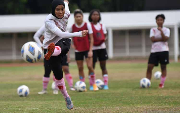 Pesepak bola Timnas Putri Indonesia Tia Darti Septiawati (kiri) menendang bola dalam pemusatan latihan di Stadion Madya, kompleks Stadion Utama Gelora Bung Karno (SUGBK), Senayan, Jakarta, Senin (3/1/2022). Pemusatan latihan tersebut sebagai persiapan untuk Piala Asia Wanita 2022 yang akan diadakan di India pada 20 Januari sampai 6 Februari 2022
