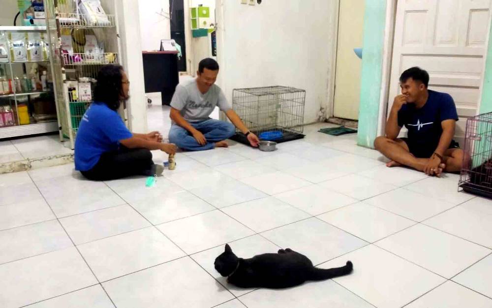 Ketua PDHI Kalimantan Tengah, drh Eko Hari Yuwono (tengah) mengobrol santai dengan salah seorang warga yang membawa hewan peliharaannya ke Klinik Canin milik drh Eko