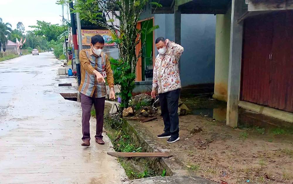 Kepala Dinas PUPR Perkim Barito Timur, Yumail J Paladuk dan Kabid Bina Marga Dodianto saat mengecek drainase yang tersumbat.