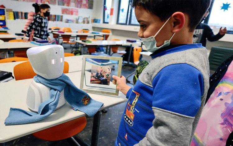 Seorang siswa menyapa Joshua melalui avatar robot (REUTERS/HANNIBAL HANSCHKE)