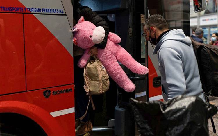 Arsip - Warga naik ke bus yang menghubungkan ke kapal feri menuju Buenos Aires saat Argentina membuka kembali perbatasannya dengan negara tetangga menyusul pandemi penyakit virus korona (COVID-19), di Montevideo, Uruguay, Jumat (1/10/2021). ANTARA FOTO/REUTERS/Ana Ferreira/aww/cfo (REUTERS/STRINGER)