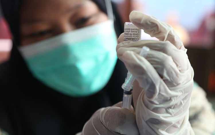  Seorang petugas hendak menyuntikkan vaksin booster di Balai RW 07 Karang Empat Kelurahan Ploso Kecamatan Tambaksari, Kota Surabaya, Jumat (14/1/2022)