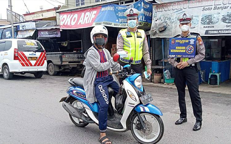 Personel Satlantas Polres Kapuas saat membagikan masker kepada pengendara di Kota Kuala Kapuas.