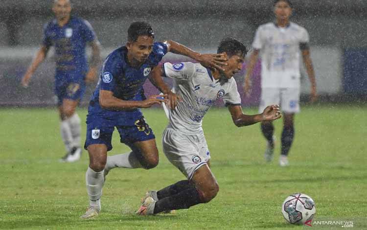 Pesepak bola Arema FC Ryan Kurnia (kanan) dihadang pemain PSIS Semarang Taufik Hidayat (kiri) dalam pertandingan sepak bola Liga 1 di Stadion I Wayan Dipta, Gianyar, Bali, Senin (17/1/2022)