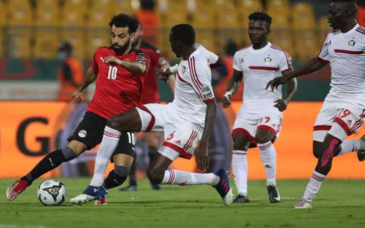 Pemain Mesir Mohamed Salah berduel dengan pemain Sudan Mustafa Karshoum dalam pertandingan Grup D Piala Afrika 2021 yang dimenangkan Mesir 1-0 di Stade Ahmadou Ahidjo, Yaounde, Kamerun, 19 Januari 2022