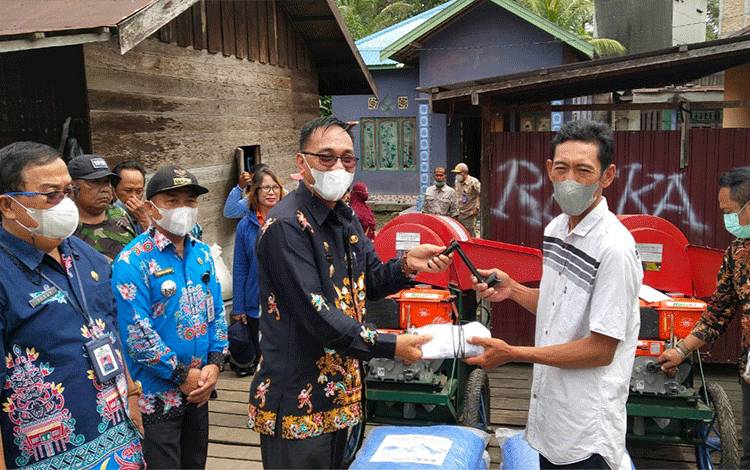 Wakil Bupati Sunardi Litang menyerahkan alat perontok padi kepada kelompok tani di Desa Dahian Tunggal