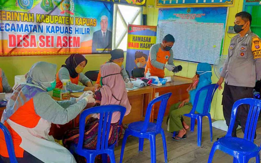 Personel Polsek Kapuas Hilir melakukan pengamanan vaksinasi covid-19 di Desa Sei Asam, Senin, 24 Januari 2022