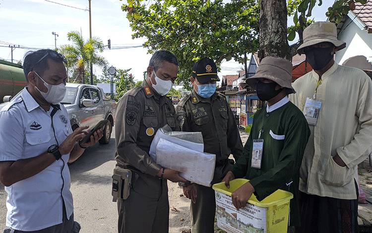Sejumlah anggota Satpol PP saat menangkap 2 dari 6 orang yang meminta-minta perempatan Jalan Dalam Kota Sampit.