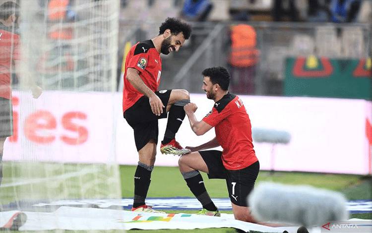 Mohamed Salah (kiri) dan Mahmoud 'Trezeguet' Hassan (kanan) melakukan selebrasi usai mencetak gol untuk Mesir dalam pertandingan perempat final Piala Afrika kontra Maroko pada 31 Januari 2022. ANTARA/AFP/CHARLY TRIBALLEAU