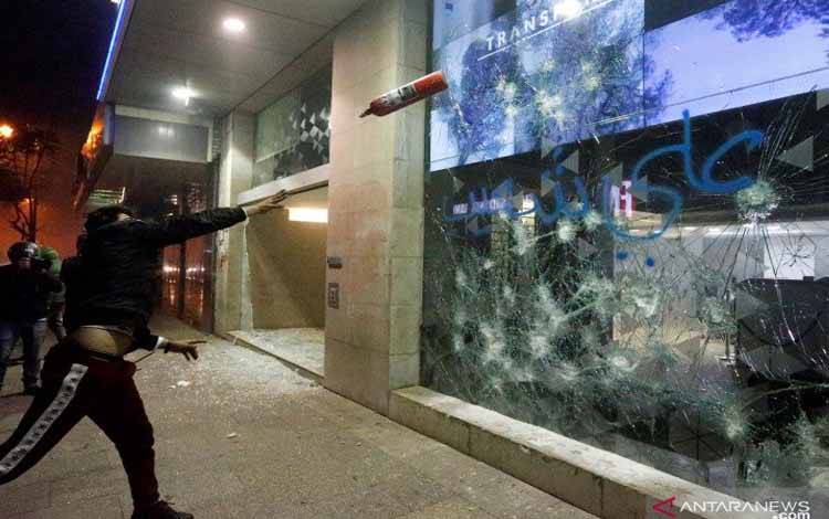 Demonstran menghancurkan jendela sebuah bank saat demonstrasi menentang krisis ekonomi yang berlanjut di Beirut, Lebanon, Selasa (14/1/2020)