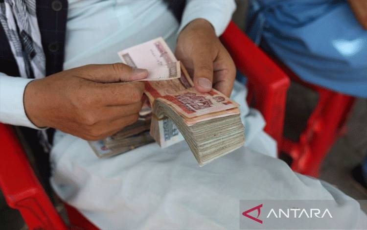 Arsip - Seorang pria Afghanistan menghitung uangnya setelah mata uang Afghanistan menghadapi devaluasi di Kabul, Afghanistan, September 2021. (ANTARA/WANA via Reuters/as)