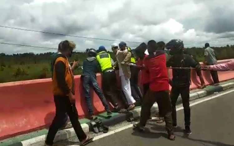Petugas kepolisian dan warga saat mengevakuasi korban kecelakaan yang terlempar dari jembatan tumbang nusa, Senin 7 Februari 2022