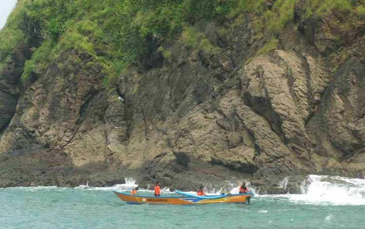 Tim SAR melakukan pencarian korban yang terseret ombak dengan menggunakan perahu di perairan Pantai Payangan Jember, Jawa Timur, Minggu (13/2/2022)