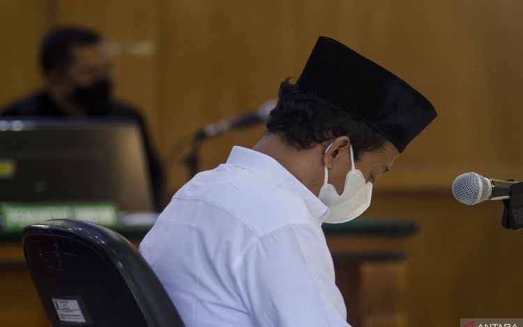 Terdakwa kasus kekerasan seksual terhadap anak Herry Wirawan mendengarkan putusan majelis hakim saat menjalani sidang vonis di Pengadilan Negeri Bandung, Jawa Barat, Selasa (15/2/2022)