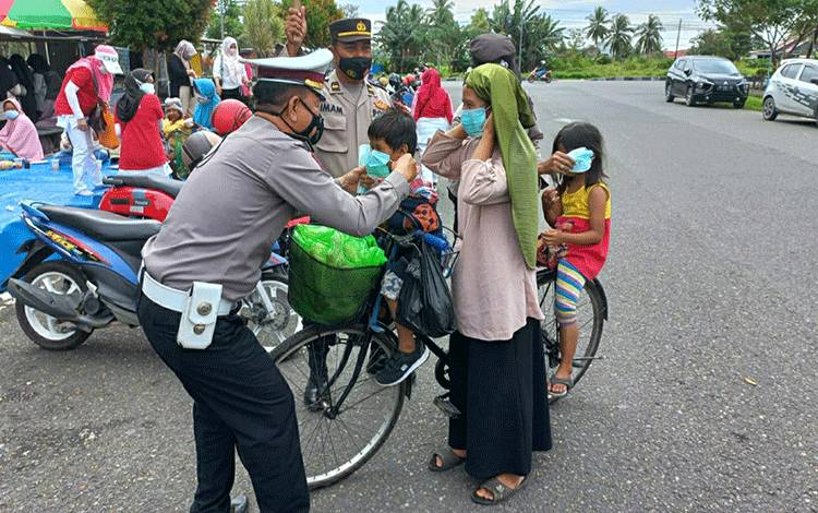 Personel Satlantas Polres Kapuas saat membagikan masker kepada masyarakat Kota Kuala Kapuas, Minggu, 27 Februari 2022.