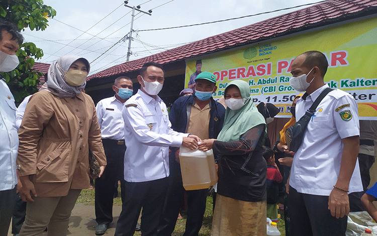  Wali Kota Palangka Raya Fairid Naparin menyerahkan minyak goreng kepada warga saat operasi pasar PT CBU di Kelurahan Langkai