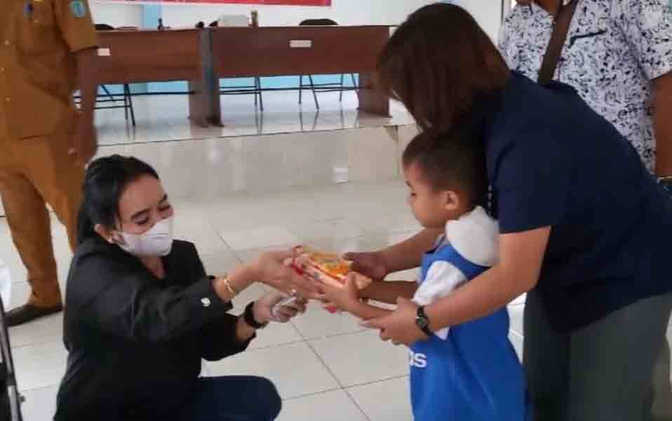 Anggota DPRD Kalteng, Maryani Sabran saat memberikan bingkisan makanan kepada anak-anak. (poto: istimewa)