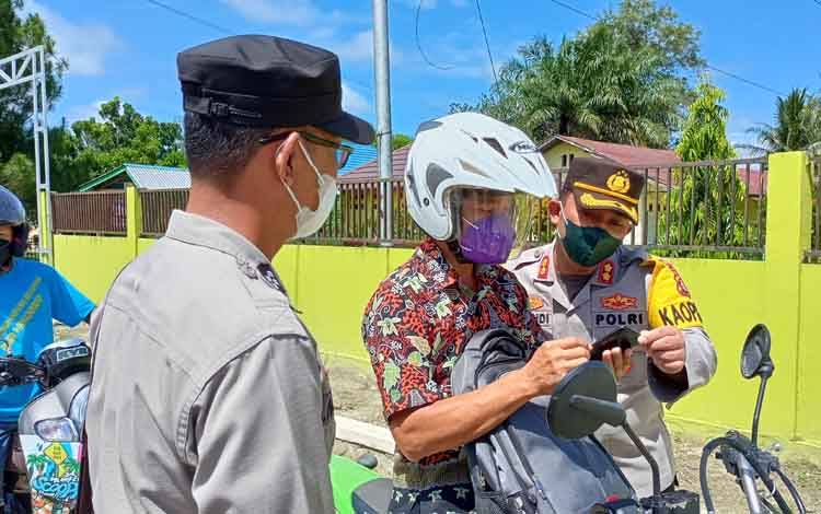 Kapolres Barito Timur AKBP Afandi Eka Putra mengecek sertifikat vaksin pengguna jalan saat razia.