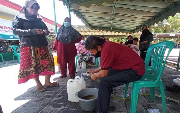 Salah seorang warga pulang membawa minyak goreng yang telah dibelinya dengan harga terjangkau di Kelurahan MB Hilir, Kecamatan MB Ketapang.