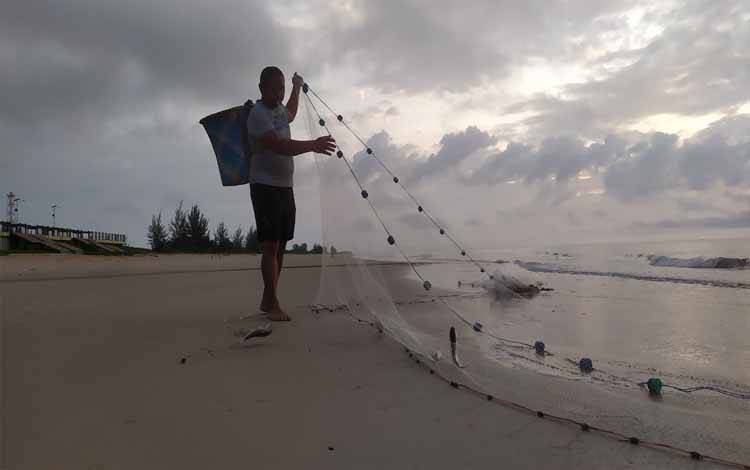 Nelayan Desa Ujung Pandaran menjala ikan di pantai saat pagi hari