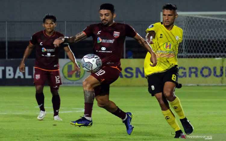 Pesepak bola Borneo FC Jonathan Bustos (tengah) berebut bola dengan pesepak bola Barito Putera Raphael Maitimo (kanan) pada pertandingan Liga 1 di Stadion Kompyang Sujana, Denpasar, Bali, Jumat (14/1/2022) 