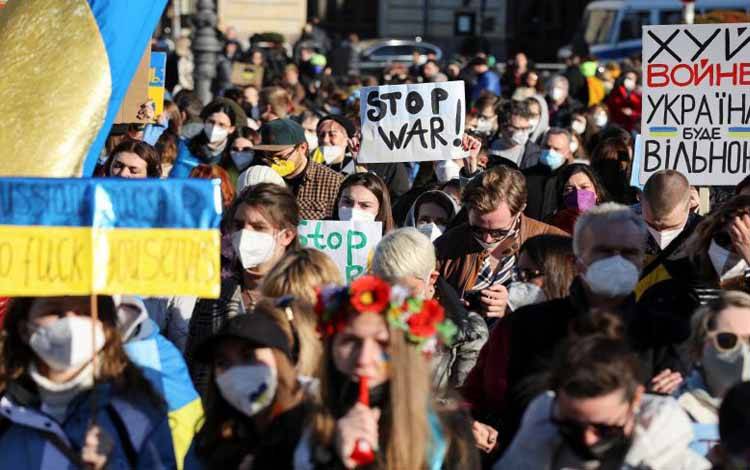 Demonstan mengangkat spanduk anti perang bertuliskan "Hentikan perang. Perdamaian dan Solidaritas untuk Rakyat Ukraina" di Berlin, Jerman, pada 13 Maret 2022, menentang invasi Rusia di Ukraina