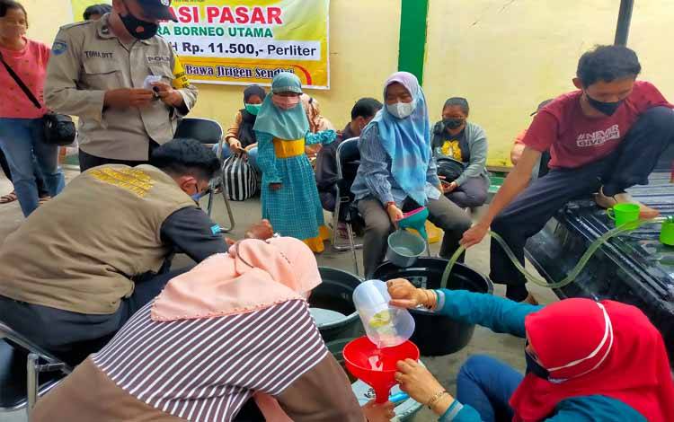 Bhabinkamtibmas Kelurahan Menteng saat membantu masyarakat dalam mengambil penyaluran Minyak Goreng 