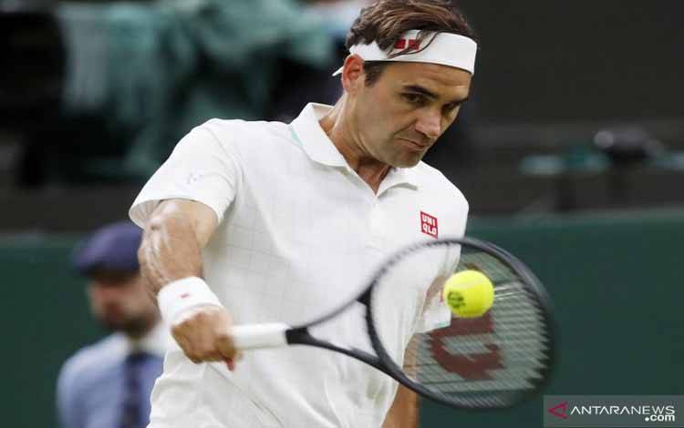 Petenis Swiss  Roger Federer mengembalikan bola ke arah lawannya petenis  Italia Lorenzo Sonego dalam laga babak 16 besar Turnamen Tenis Wimbledon, di  All England, London, Inggris, Senin (5/7/2021). Fedrerer melaju ke babak perempat final setelah mengalahkan  Sonego straight set (7-5, 6-4. dan 6-2)
