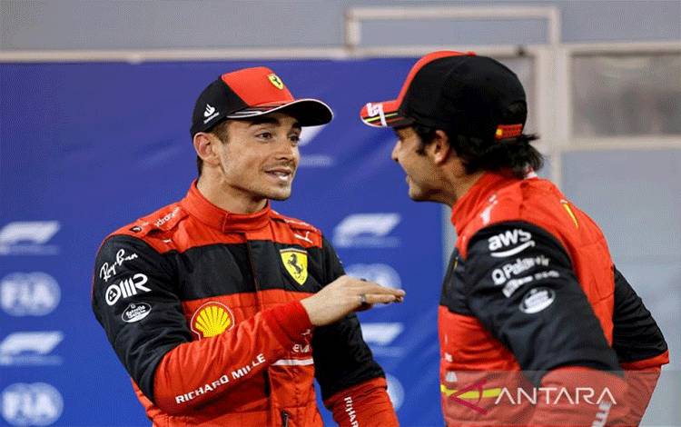 Pebalap Ferrari Charles Leclerc (kiri) berbincang dengan rekan setimnya Carlos Sainz seusai meraih pole position balapan pembuka musim Formula 1 2022 Grand Prix Bahrain dalam sesi kualifikasi di Sirkuit Internasional Bahrain, Sakhir, Bahrain, Sabtu (19/3/2022). (ANTARA/REUTERS/Hamad I Mohammed)