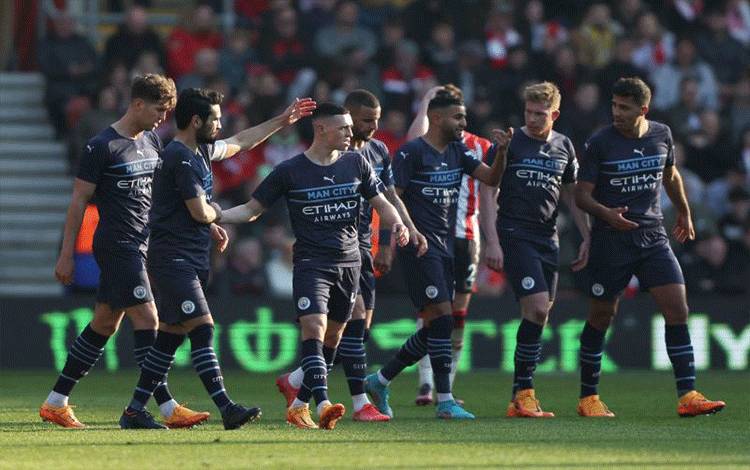 Pemain Manchester City Phil Foden merayakan gol bersama rekan-rekan satu tim ketika City menang 4-1 atas Southampton dalam perempatfinal Piala FA di Stadion St Mary's, Southampton, Inggris, 20 Maret 2022. (REUTERS/IAN WALTON)