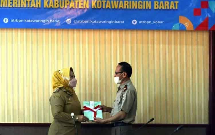 Bupati Kobar, Nurhidayah menerima secara simbolis sertifikat hak pakai pemkab dari BPN.