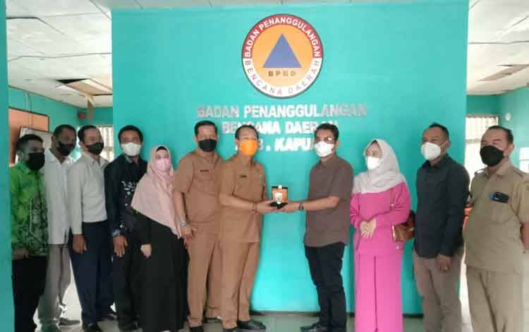 Kepala Pelaksana BPBD Kapuas, Panahatan Sinaga saat menerima cinderamata dari kunjungan DPRD Hulu Sungai Tengah, Senin 21 Maret 2022