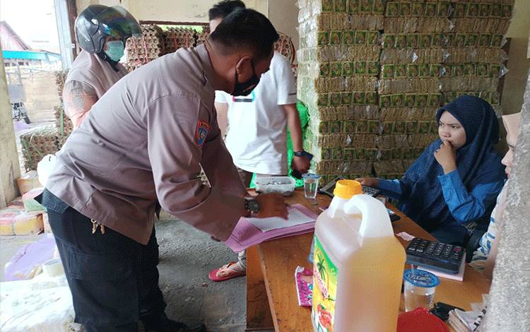 Personel Satbinmas Polres Kapuas saat mengecek ketersediaan stok minyak goreng di pasaran.