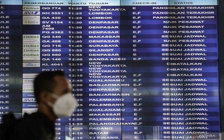 Dokumentasi pemakai jasa penerbangan berjalan di depan papan jadwal penerbangan domestik di Terminal 3 Bandara Soekarno-Hatta, Tangerang, Banten, Selasa (8/3/2022). ANTARA FOTO/Fauzan