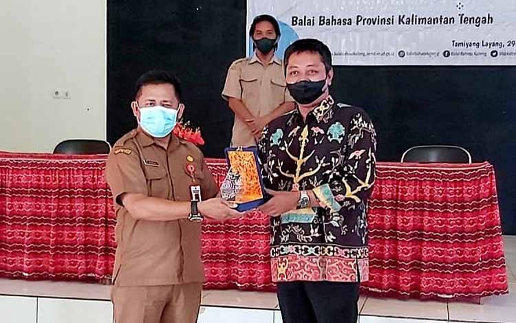 Kepala Dinas Pendidikan Barito Timur, Sabai menerima cenderamata dari Balai Bahasa Provinsi Kalimantan Tengah usai membuka Pelatihan Revitalisasi Sastra Lisan Tumet Leut