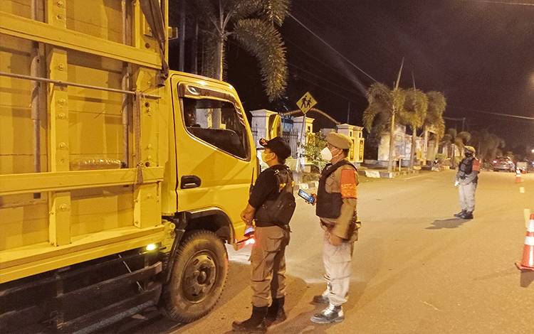 Personel Satpol PP dan TNI saat mensosialisasikan syarat mudik lebaran kepada pengguna jalan yang melintas di depan Kantor Bupati Barito Timur.