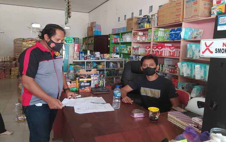 Personel Polsek Hanau mengecek ketersediaan sembako di salah satu toko di Pembuang Hulu
